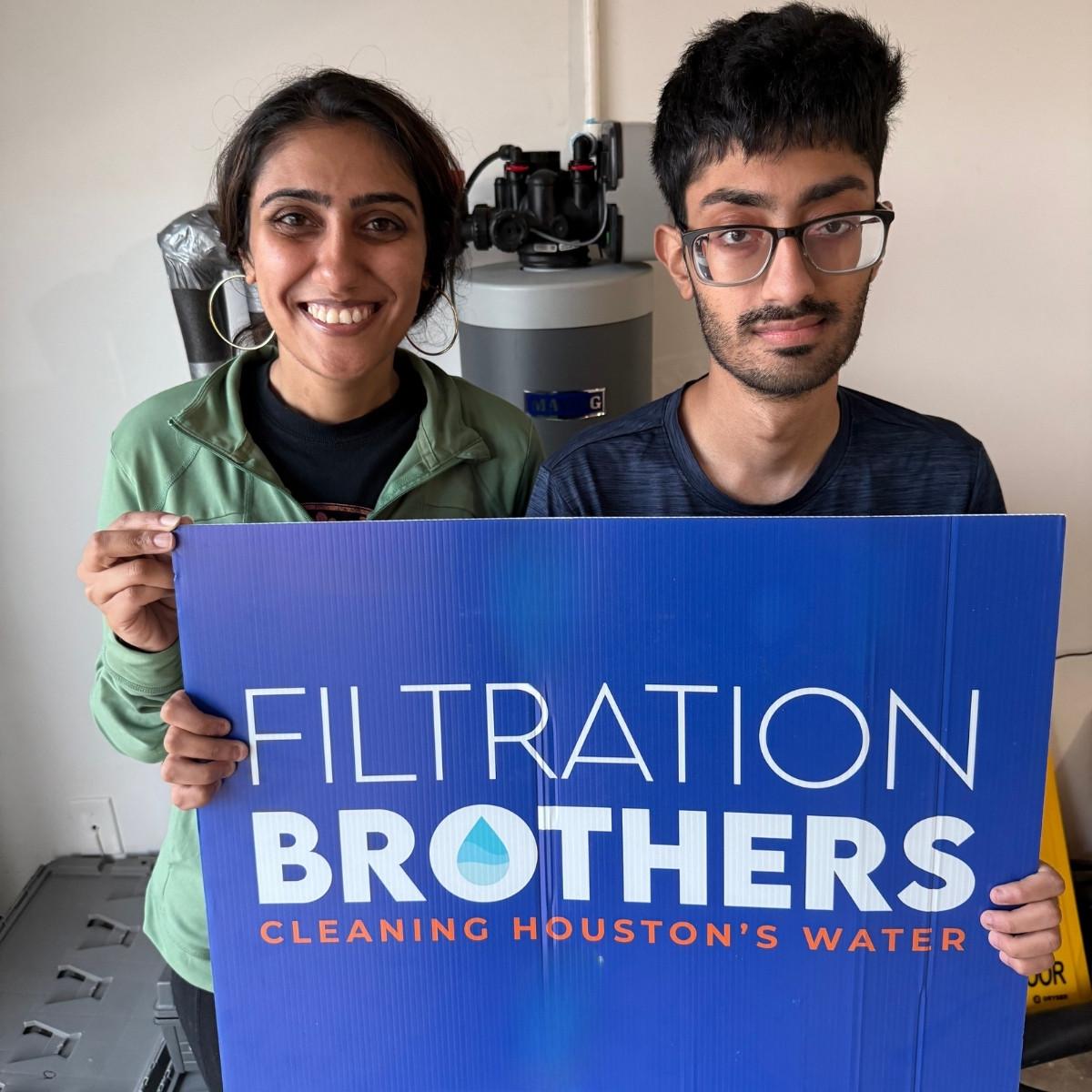 Homeowners with their newly installed whole-home water filtration system