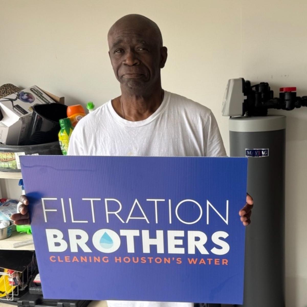 Customer with a Filtration Brothers team member next to their new system